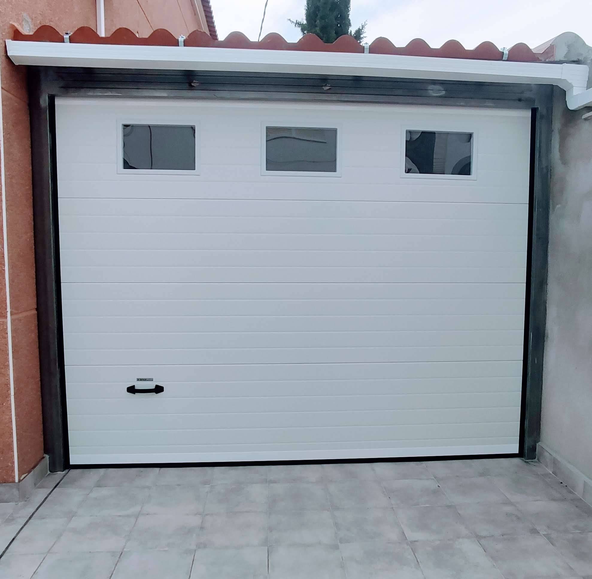 Puerta seccional blanca con ventanas, vivienda particular