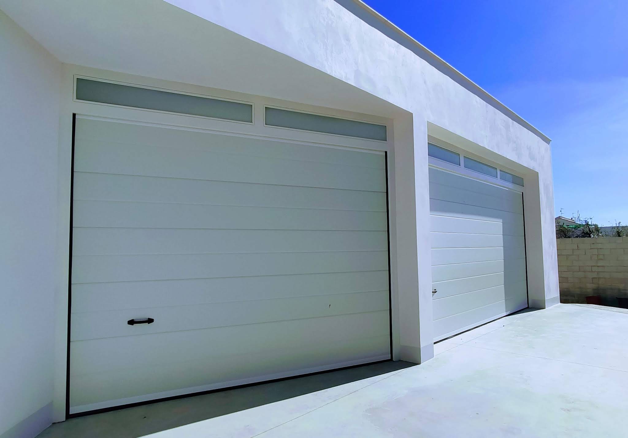 Doble puerta seccional con óculos en vivienda nueva